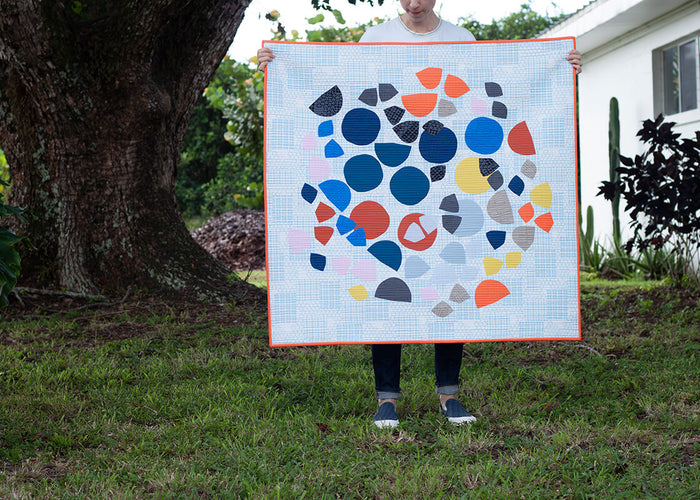 appliqué quilt with colorful shapes on a blue background