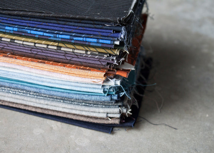 stack of Instead fabric and coordinating solids