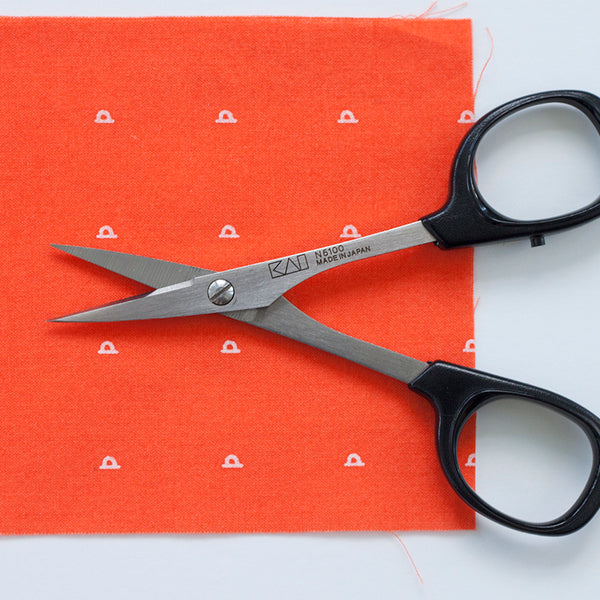 opened scissor on red fabric