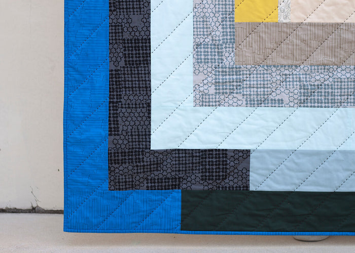 hand quilted quilt with a dark, thick thread and blue, black and yellow fabrics